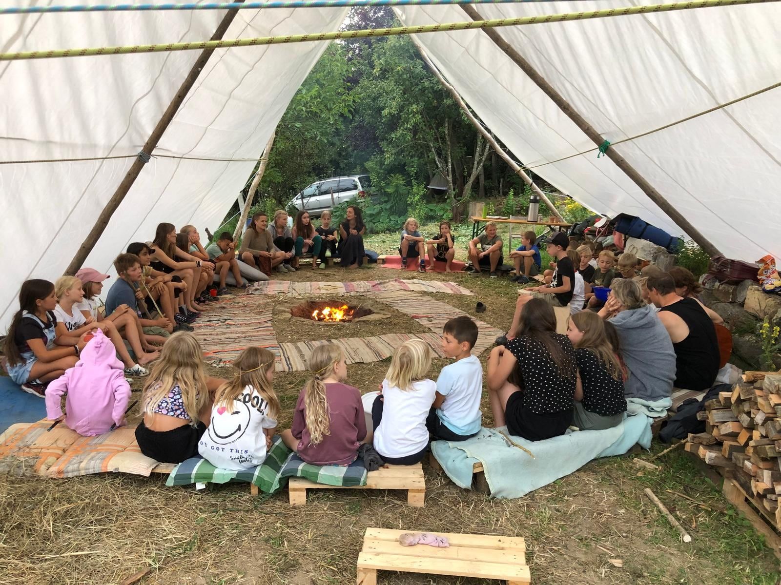 Morgenkreis um die Feuerstelle unter dem großen Tarp